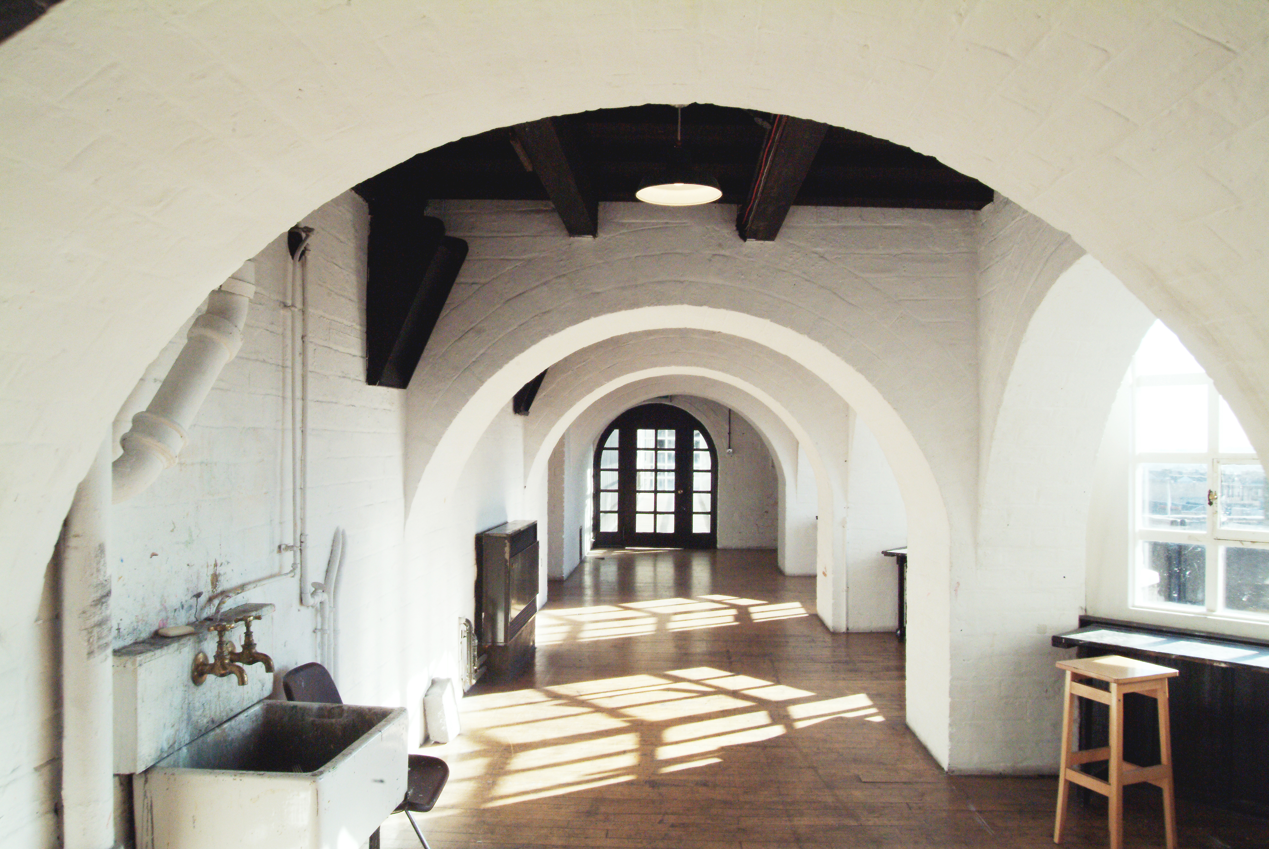 A view of one of the corridors, known as a loggia, painted white and with arches