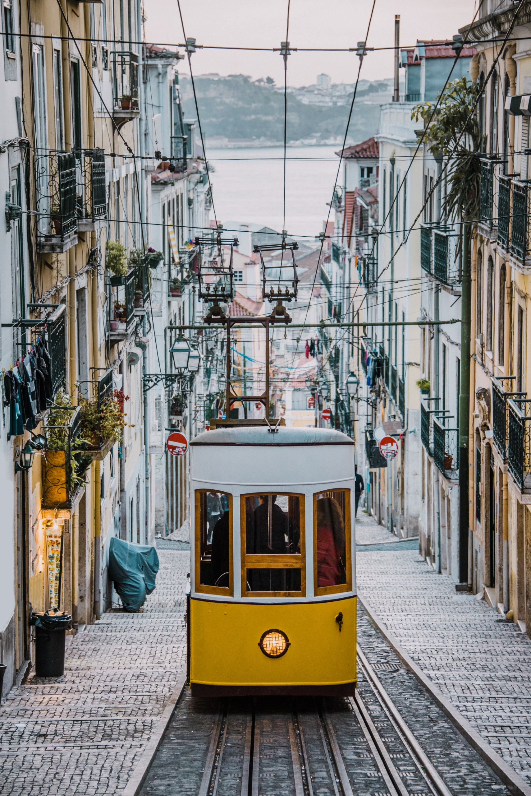 Yellow tram climbing a steep Lisbon street
