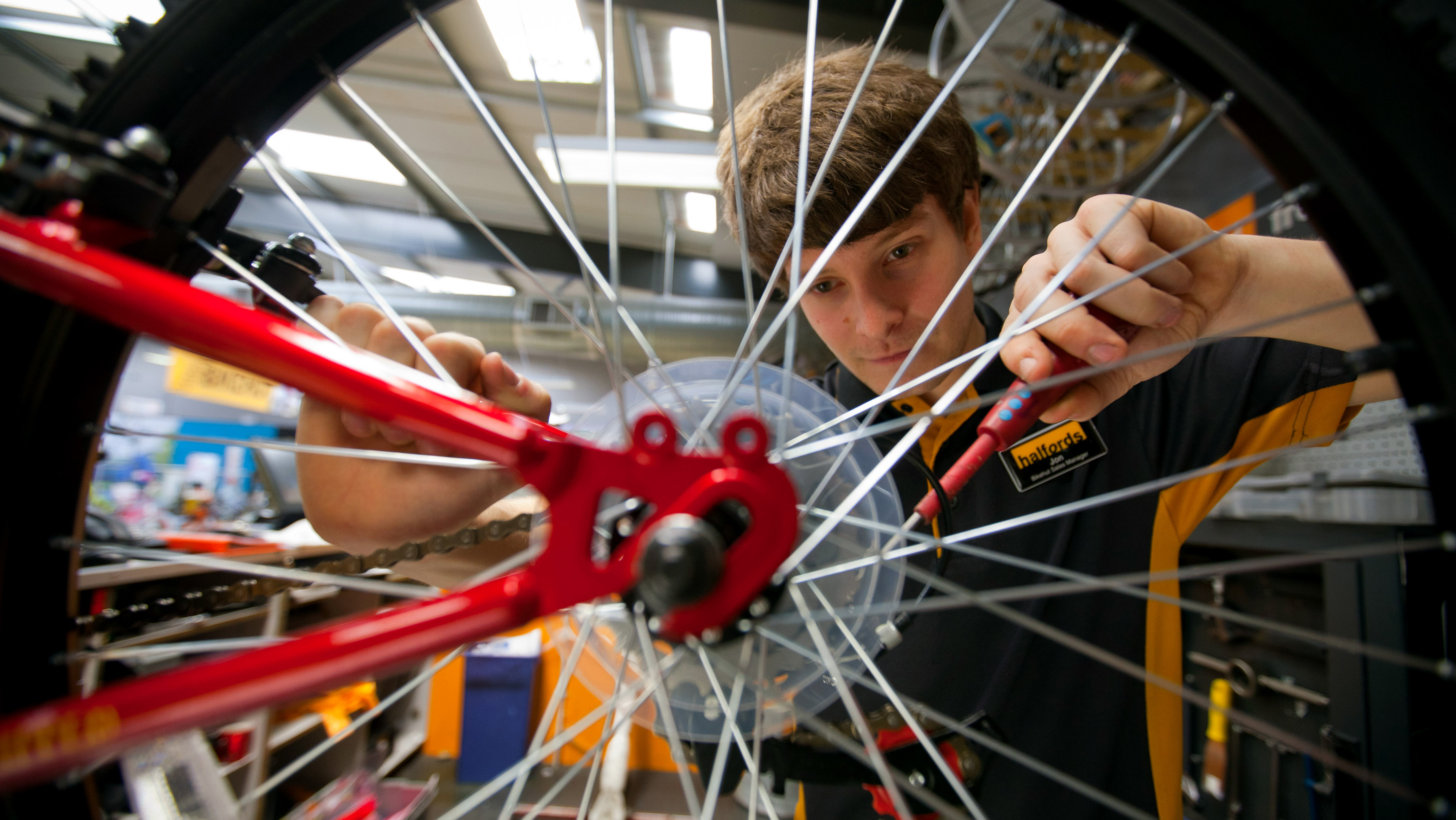 Young bike mechanic works on a wheel
