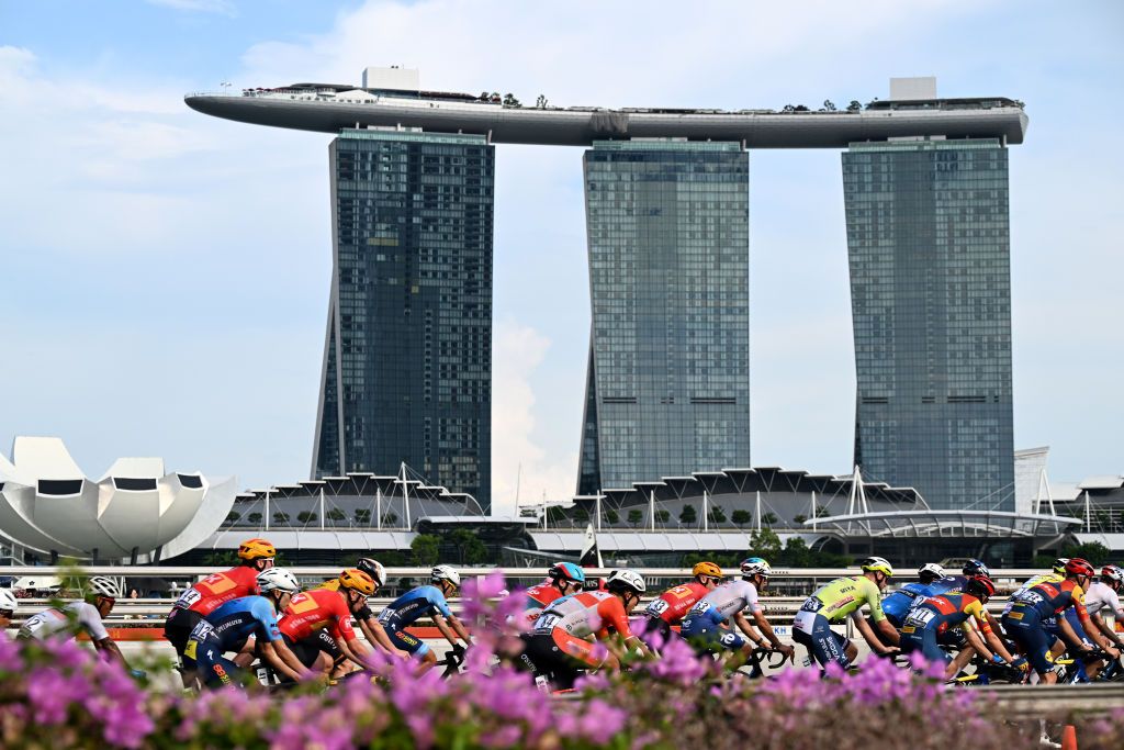 SINGAPORE SINGAPORE NOVEMBER 10 LR Fabien Grellier of France and Team TotalEnergies Laurent Rex of Belgium and Team IntermarcheCircusWanty Patrick Konrad of Austria and Team Lidl Trek and a general view of the peloton competing with the Marina Bay Sands building in the background during the 3rd Tour de France Prudential Singapore 2024 Criterium a 575km one day race from Singapore to Singapore on November 10 2024 in Singapore Photo by Tim de WaeleGetty Images