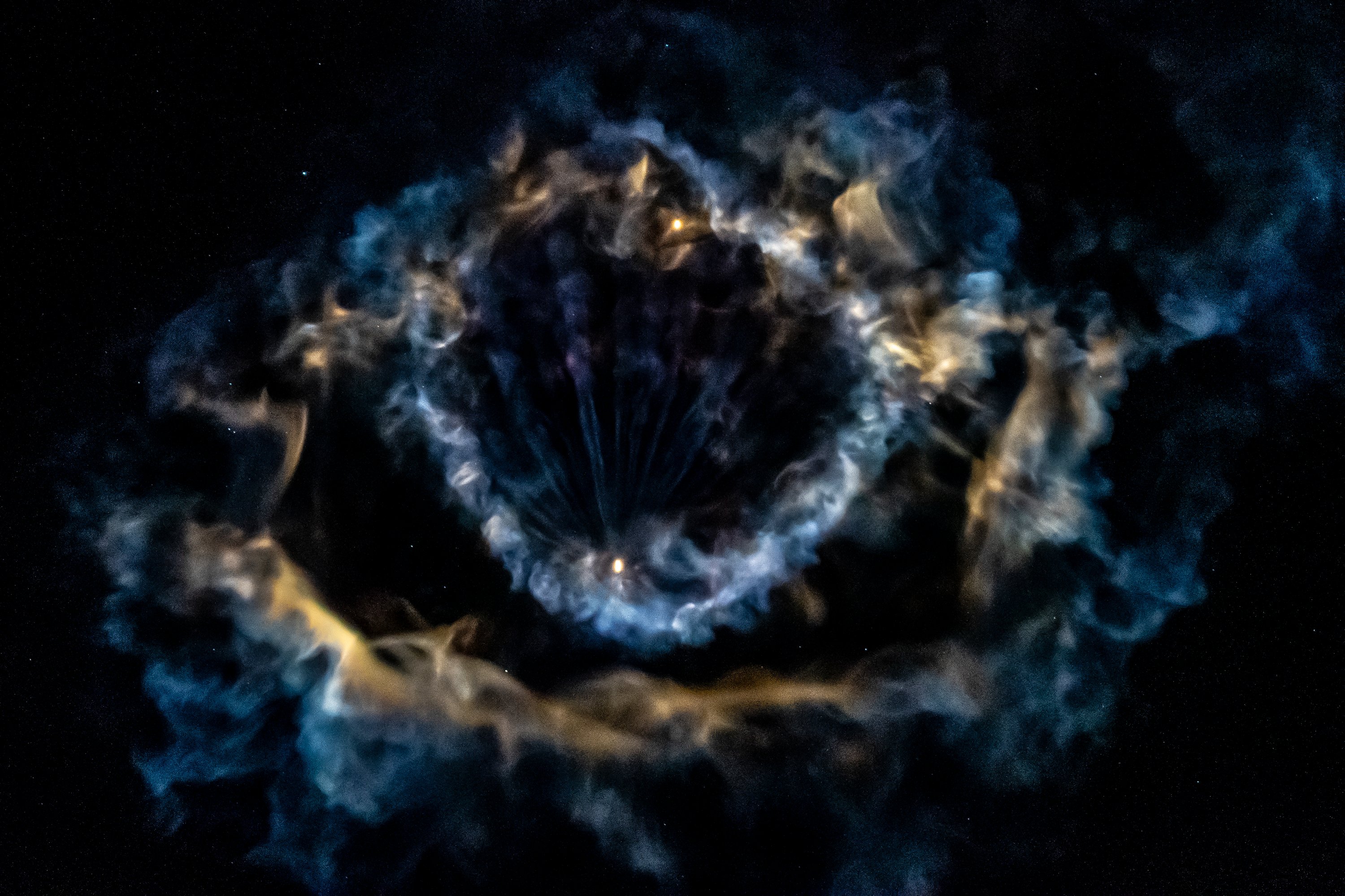 Swirls of blue and yellow gas with a bright dot in the middle are over a black background