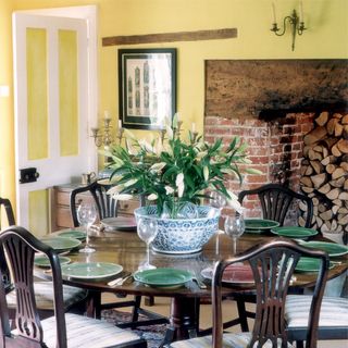 dining room with dining table and chairs with plates and glasses with firewood