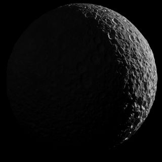 This view of Saturn's moon Mimas shows the moon as it would have appeared through a powerful telescope, with the left side in shadow and barely lit by reflected light off Saturn.