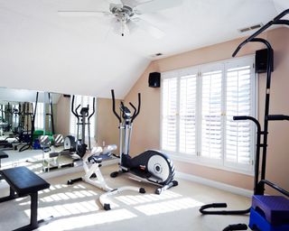 Home gym with large window with shutters
