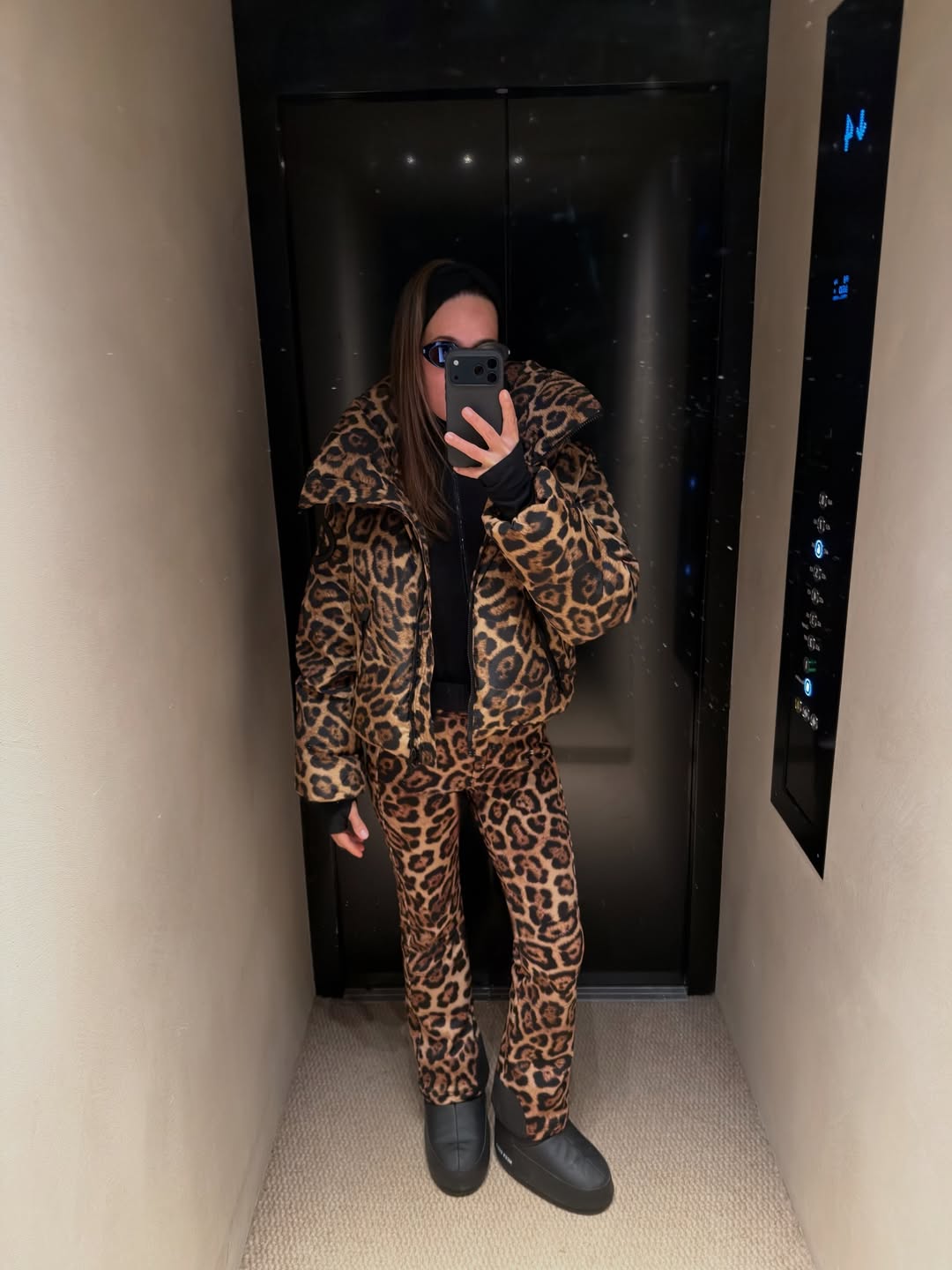 COPENHAGEN, DENMARK - FEBRUARY 01: A guest is seen wearing cap, black down feather jacket, skirt, red moon boots outside Gestuz during Copenhagen Fashion Week Autumn/Winter 2022 on February 01, 2022 in Copenhagen, Denmark. (Photo by Christian Vierig/Getty Images)