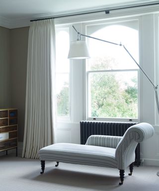 Neutral coloured upholstered daybed in front of a large window by Fran Hickman