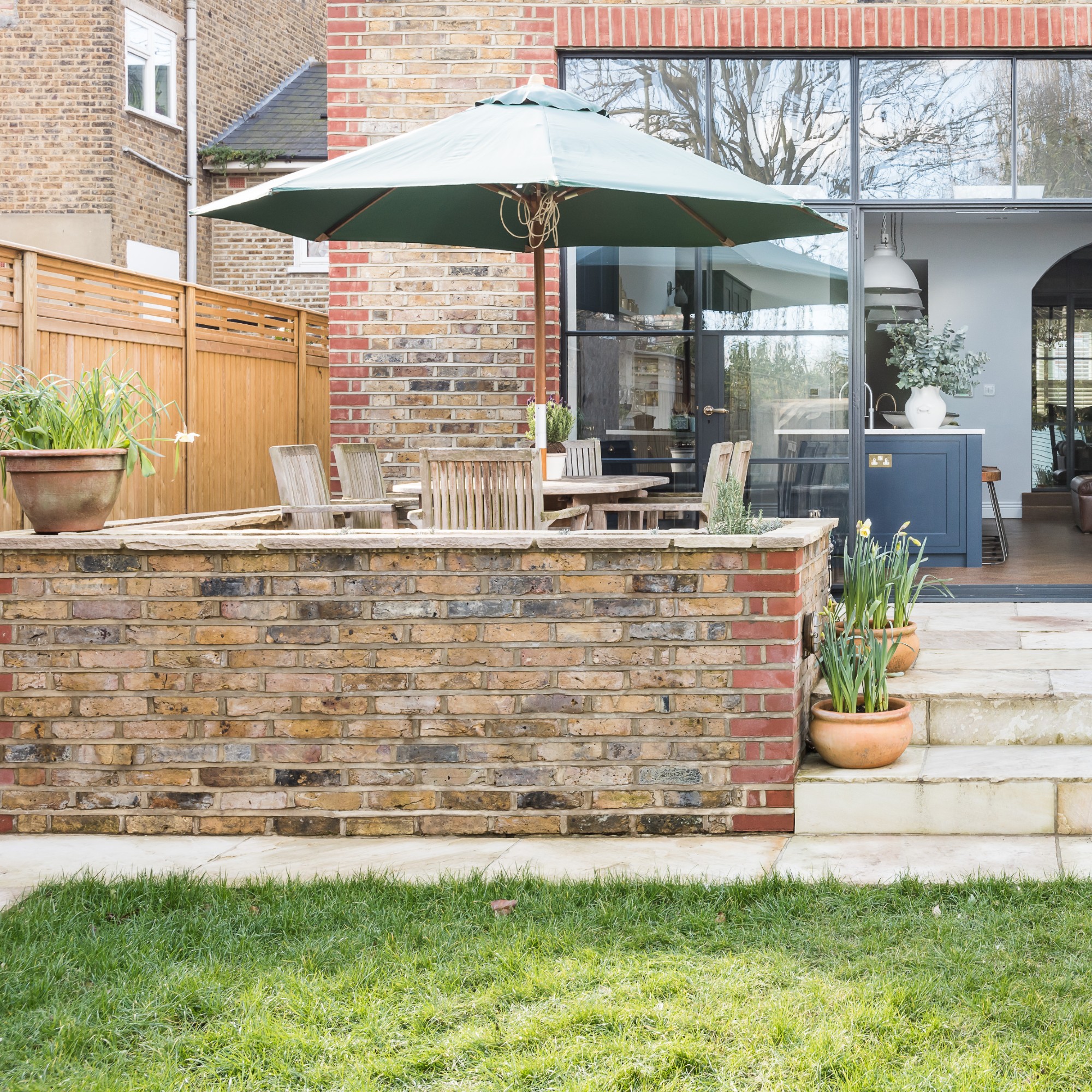 A patio with garden furniture and a wooden privacy screen to the side