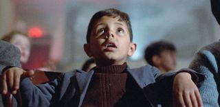 Salvatore Cascio as a young boy sitting in front of a cinema screen