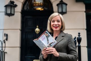 Lucy Worsley, book in hand, outside Sherlock Holmes' fictional residence in London's Baker Street.