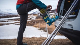 A woman puts on her ski boots