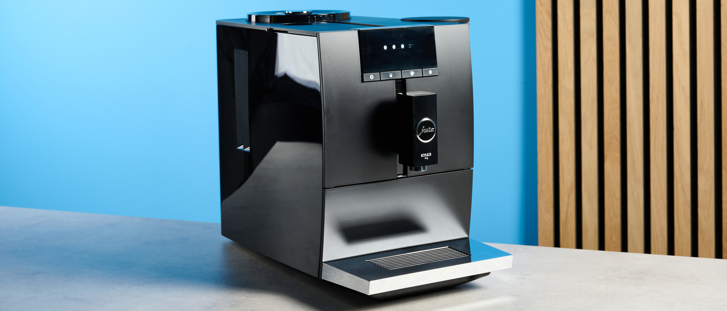 the jura ena 4 automatic coffee machine in piano black with a faceted water tank and bright screen