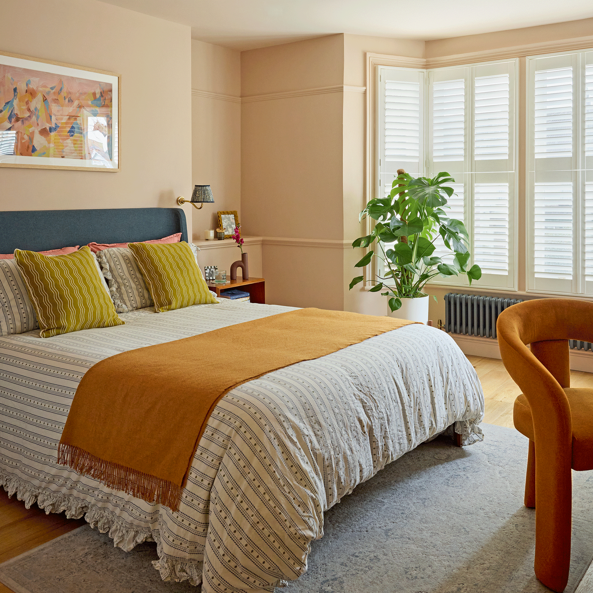a bedroom with peach painted walls and yellow and blue accents