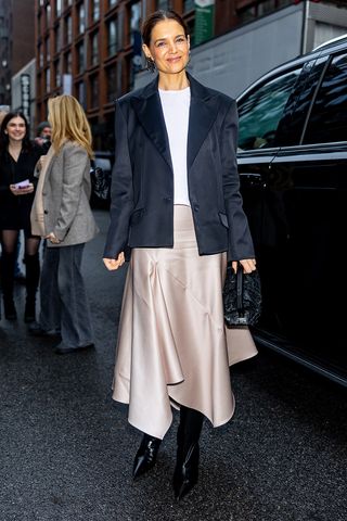 Katie Holmes wearing a blazer and satin handkerchief skirt at NYFW