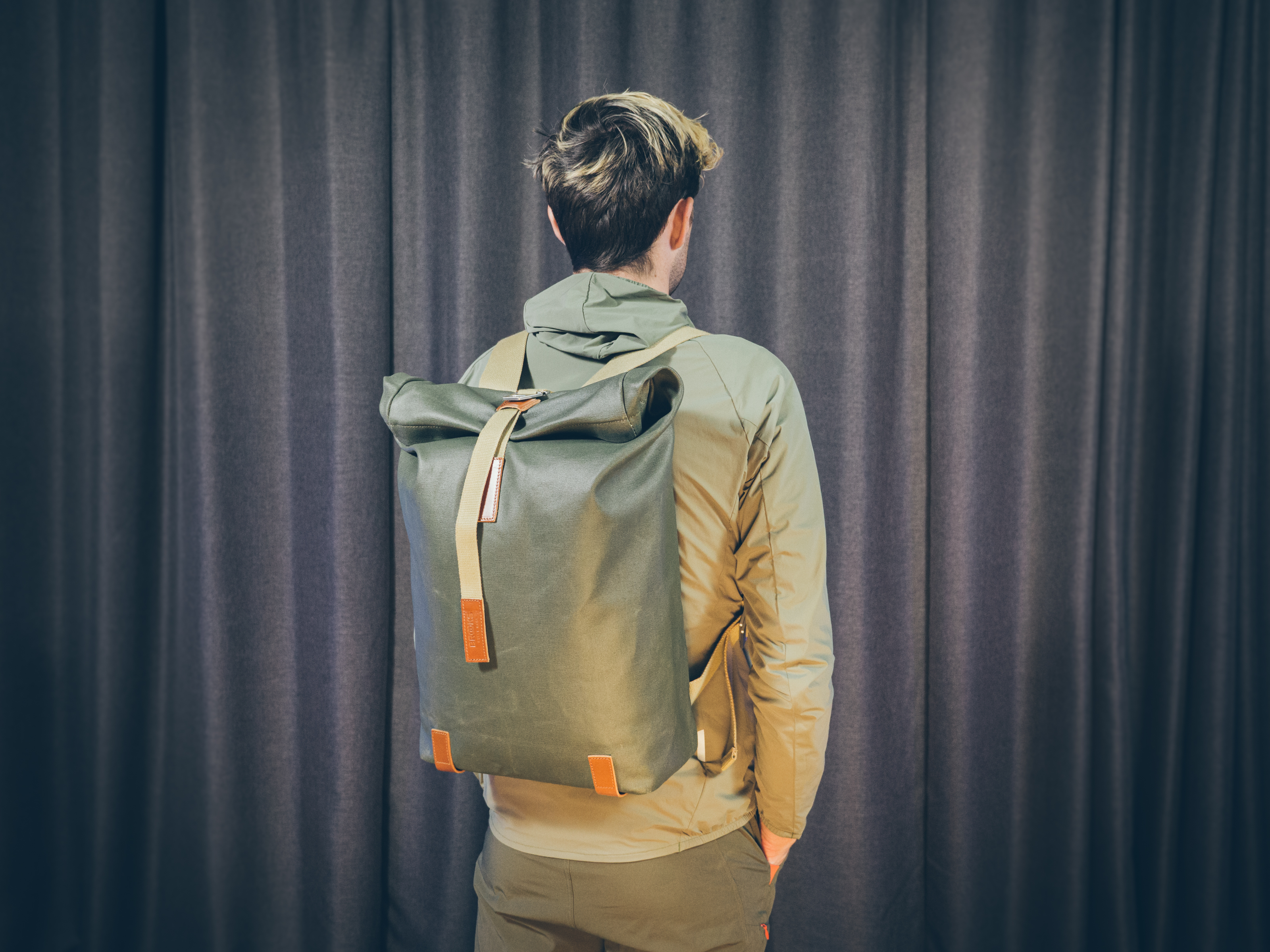 Will Jones, wearing one of the best backpacks for cycling, stands in front of a wall