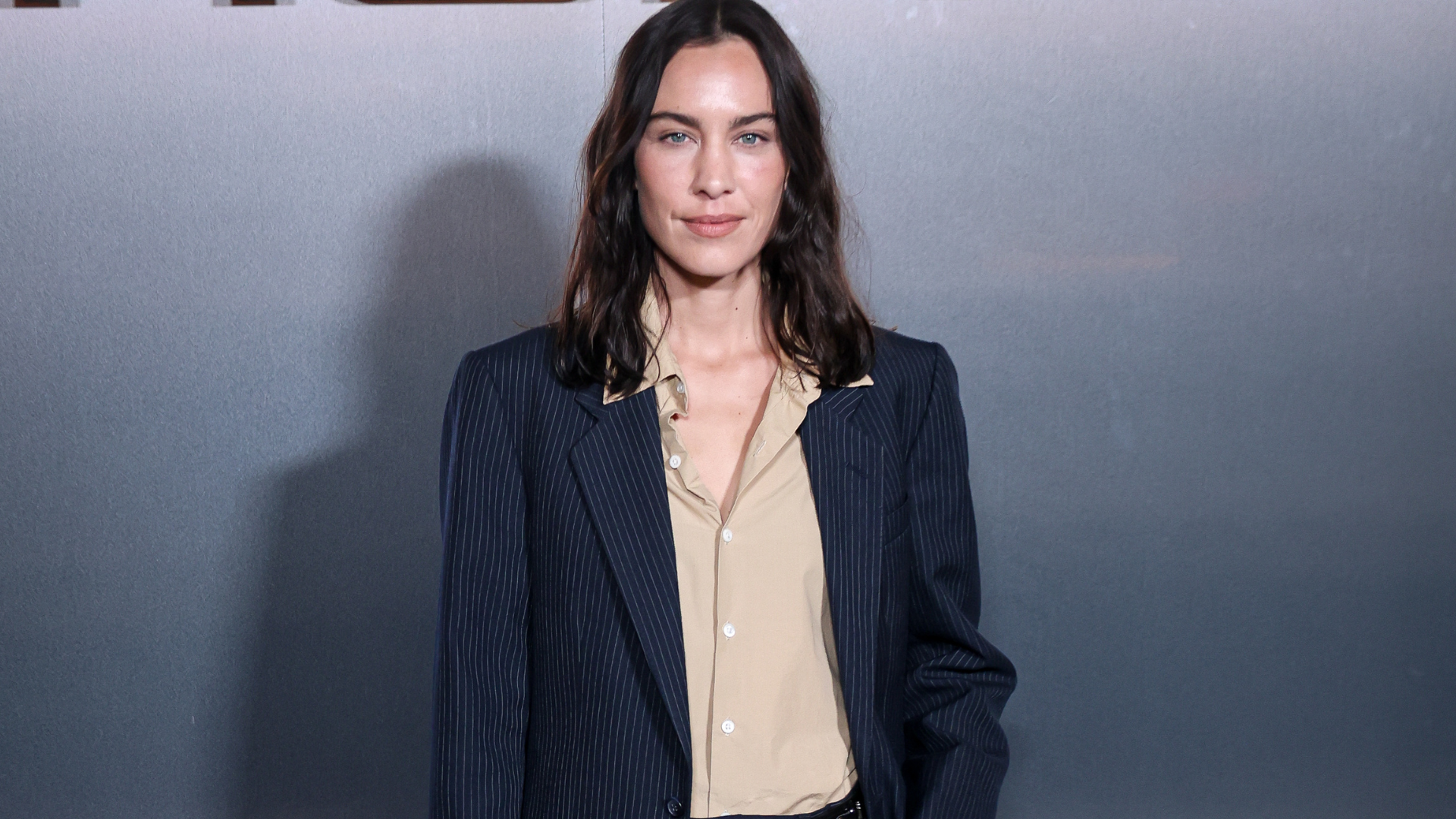 Alexa Chung wears a navy pinstripe suit with dark purple slim-line Hoff Trainers.