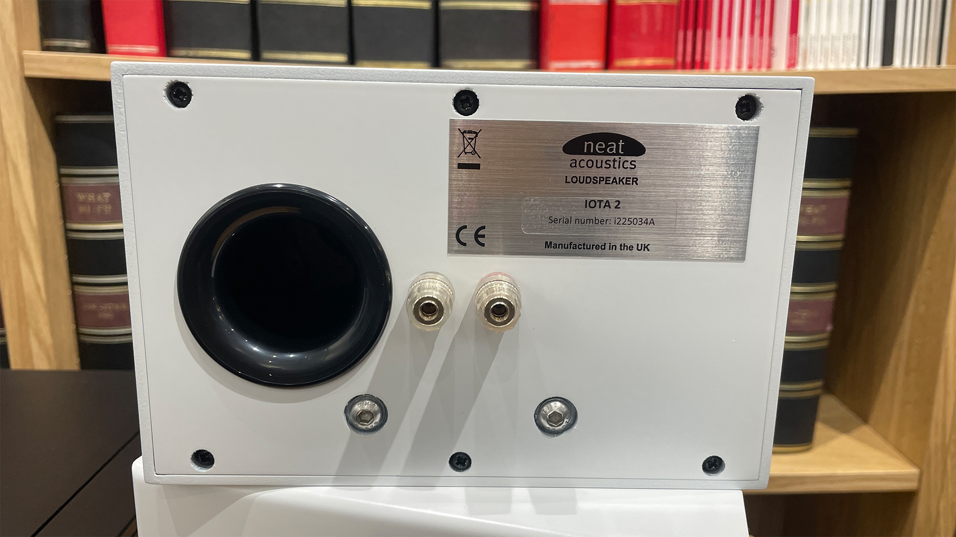 Rear panel of Neat Iota II speakers showing reflex port, speaker terminals and screws