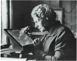 Annie Jump Cannon examines a photographic plates of the night sky. She created the stellar classification system still used today.