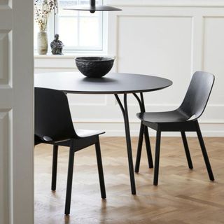 A round black metal dining table with matching chairs