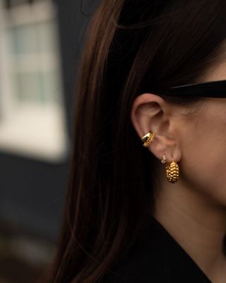 Woman with several gold piercings in her ear.