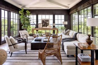 black sunroom with white furnishings and natural materials