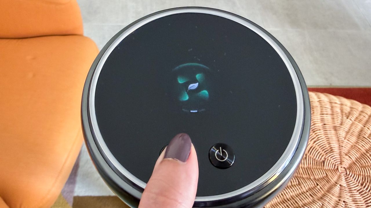 A thumb pressing on the suction button on the Dreame Z50 Station