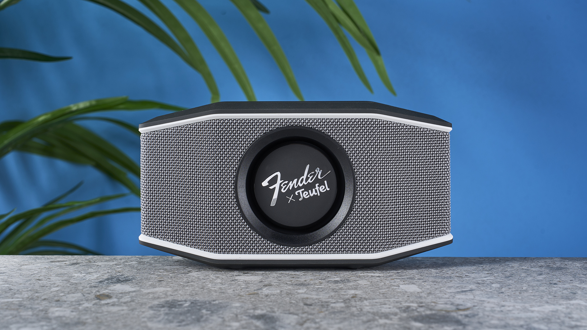 a retro-inspired bluetooth speaker 8 inches long and 4 inches tall with a circular woofer in the center branded with Fender and Teufel