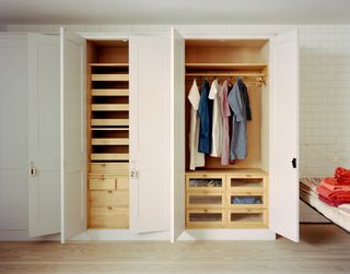 a closet with linen clothes hanging