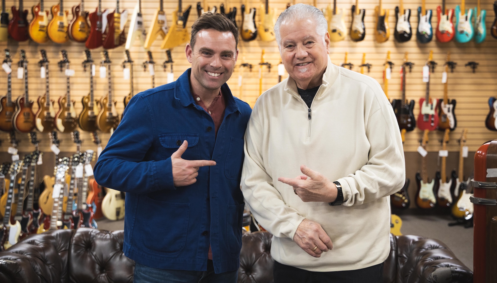 Ben Montague (left) and Norman Harris, stood together in front of a wall of guitars at Norman's Rare Guitars