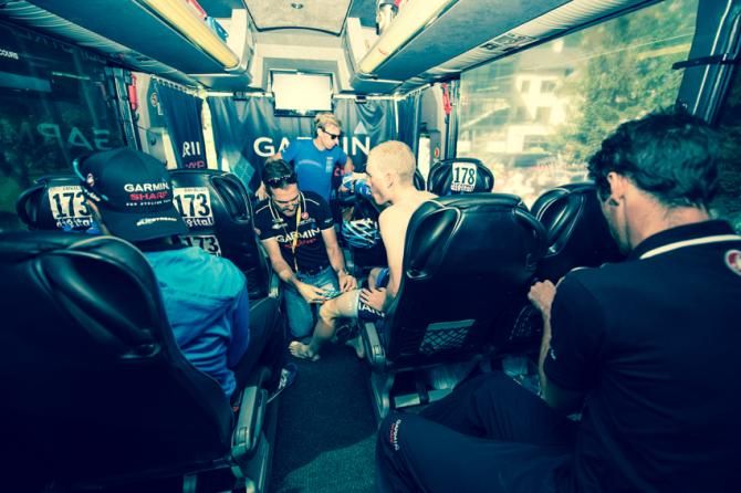 Andrew Talansky has his knee taped in the team bus before the stage in Bourg D&rsquo;Oisans with David Millar and Tom Danielson preparing for their team meeting