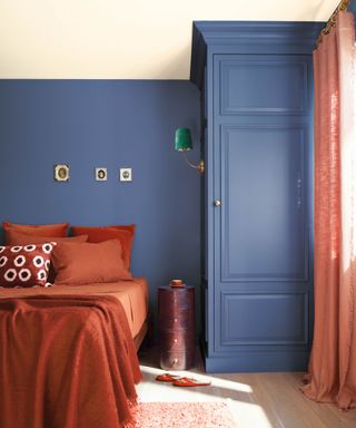 blue bedroom walls with red curtains and red bedding