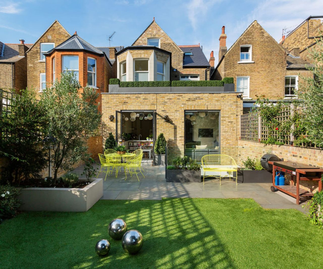 A brick kitchen extension leading into a garden dining area
