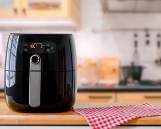 Black air fryer with gingham cloth in kitchen