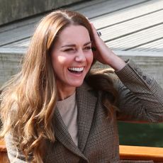 Kate Middleton smiling, running a hand through her hair
