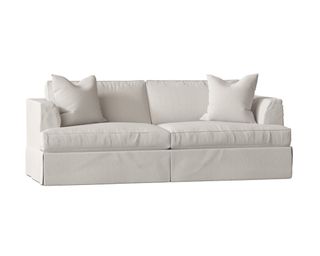 A white slip-covered sleeper sofa