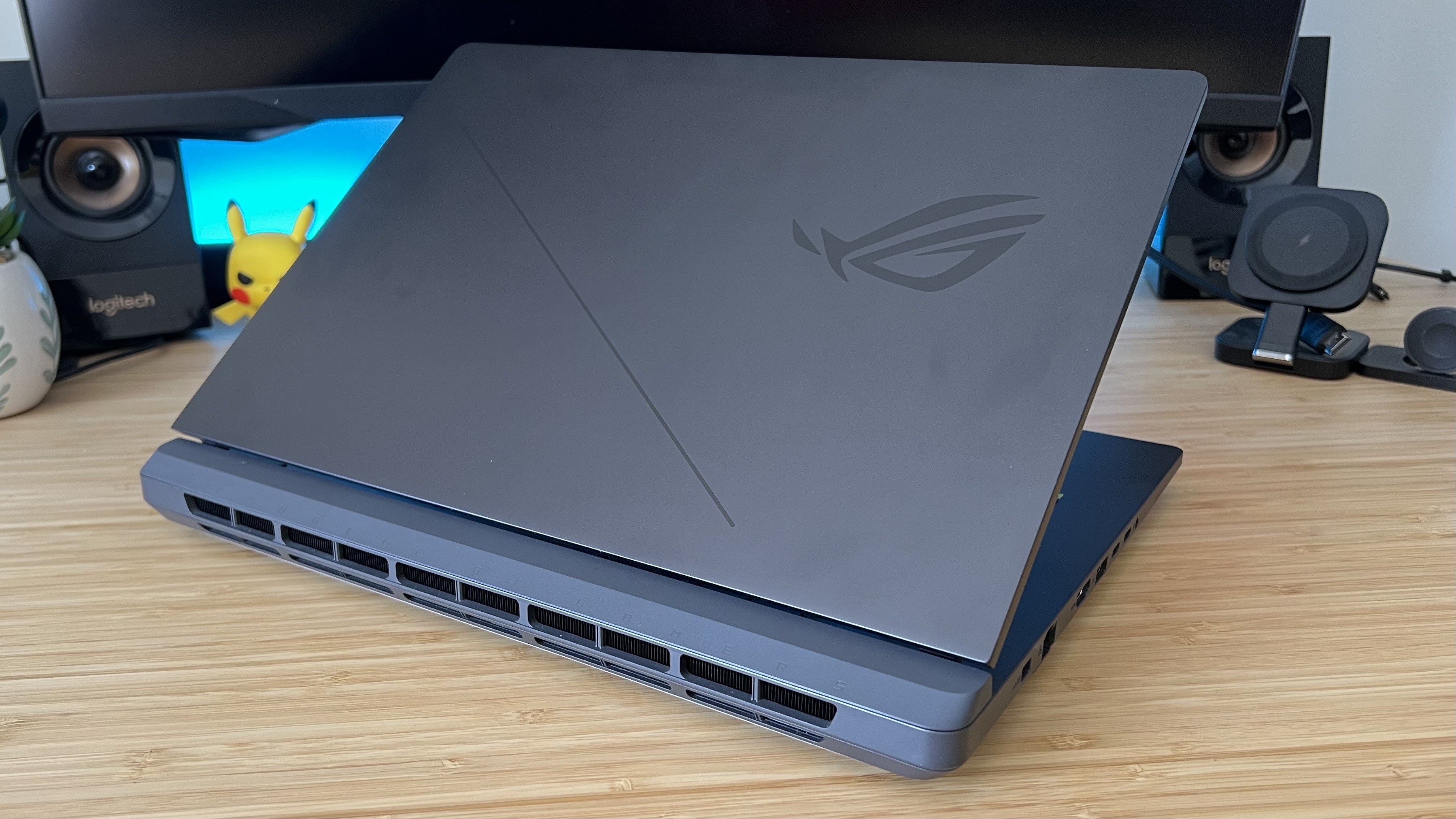 Asus ROG Strix G16 gaming laptop lid and rear vents on a wooden desk