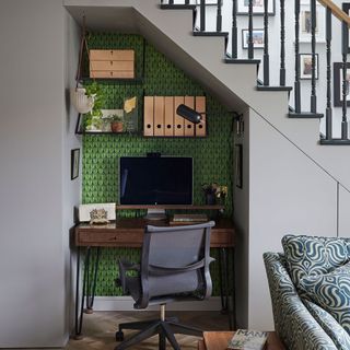 Home office with wallpaper panel underneath staircase