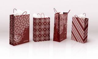 Four red gift bags displayed next to each other with different graphic designs.