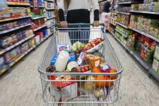 A trolley full of food in a supermarket aisle