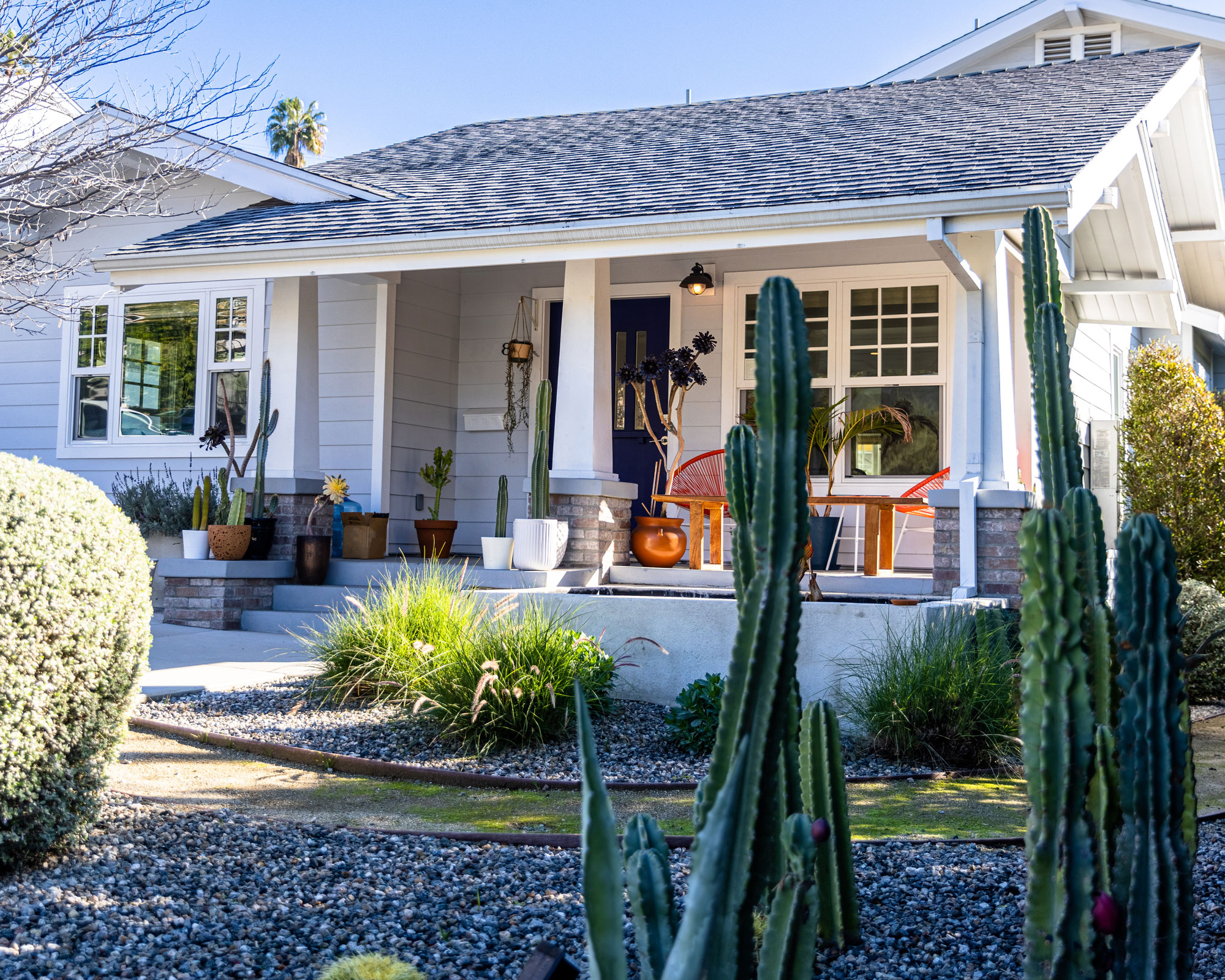 front yard patio with garden furniture and gravel landscaping, cacti, ornamental grasses and clipped topiary