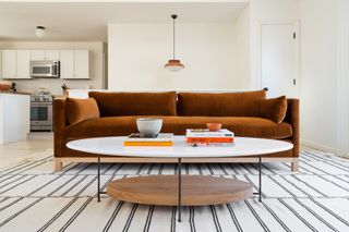 a round coffee table with an orange sofa