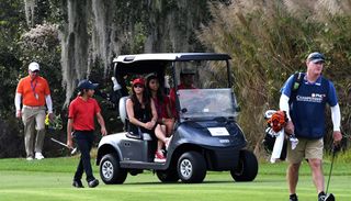 Woods drives his cart with his family