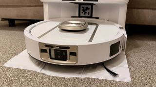 Shark PowerDetect 2-in-1 ThermaCharged NeverTouch photographed on a carpet with docking station