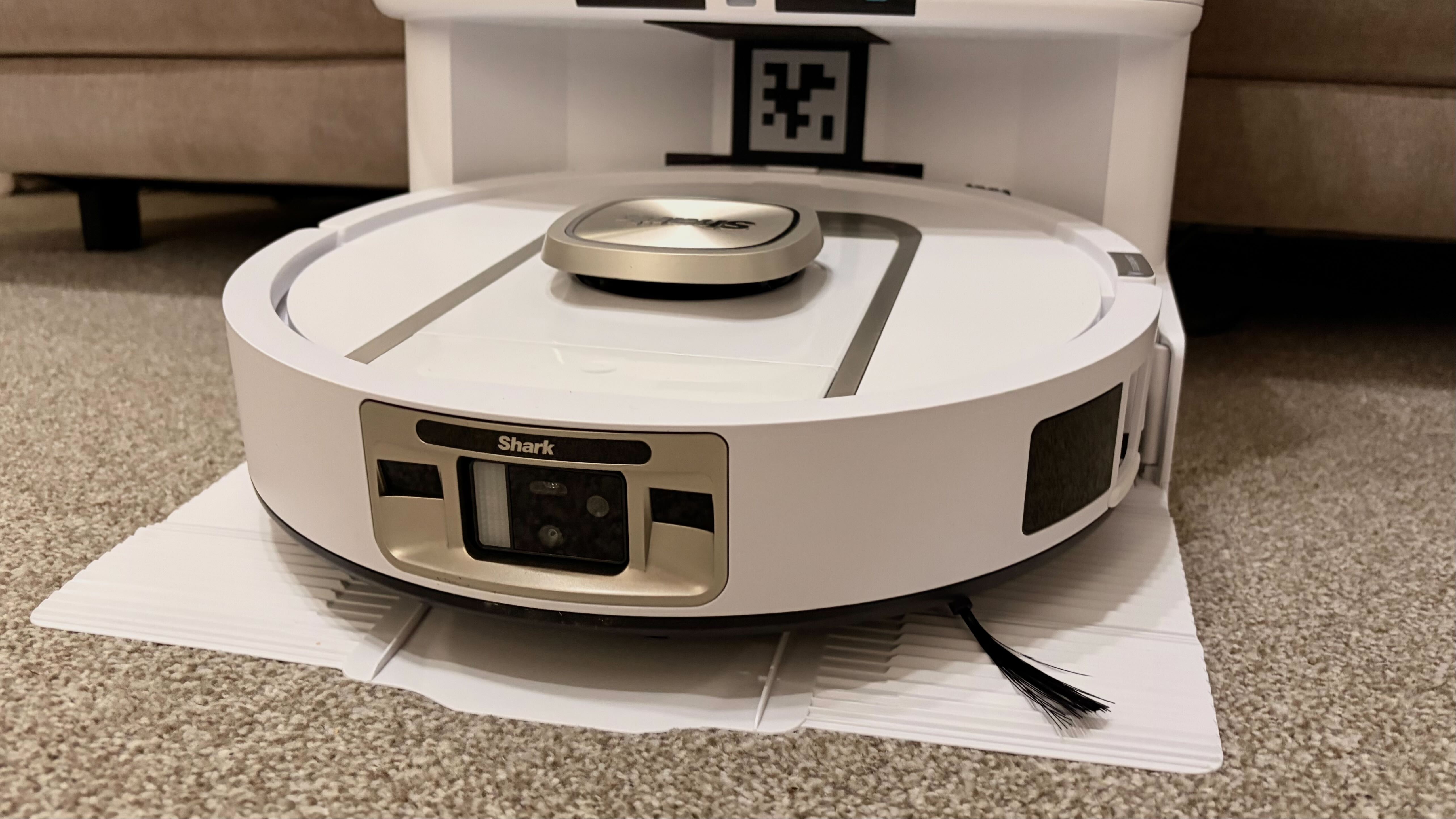 Shark PowerDetect 2-in-1 ThermaCharged NeverTouch photographed on a carpet with docking station