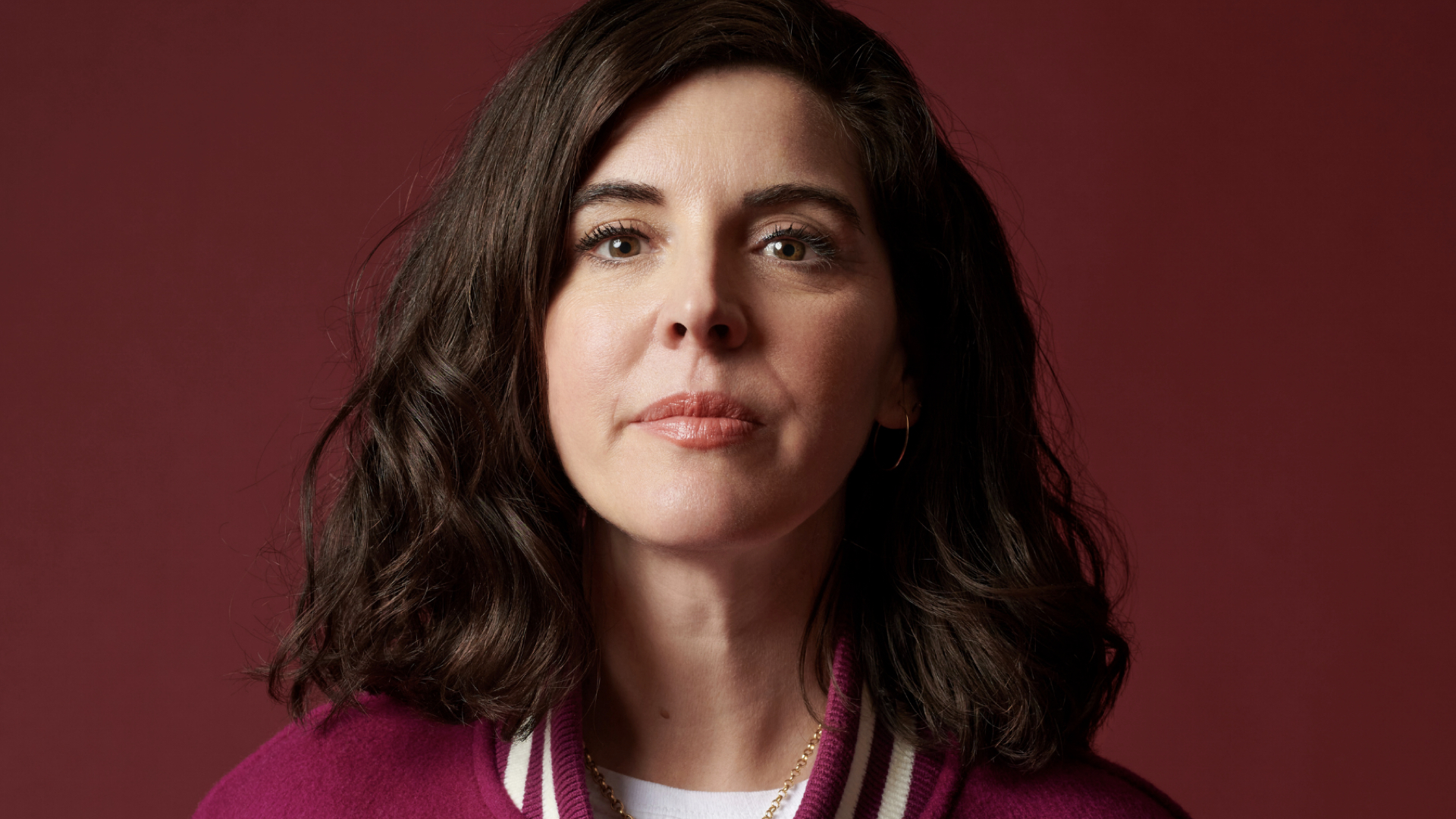 woman with dark hair and eyes in a red top