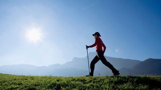 A woman Nordic walking on a hill