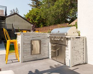 Sociable outdoor kitchen set-up with bar stools.