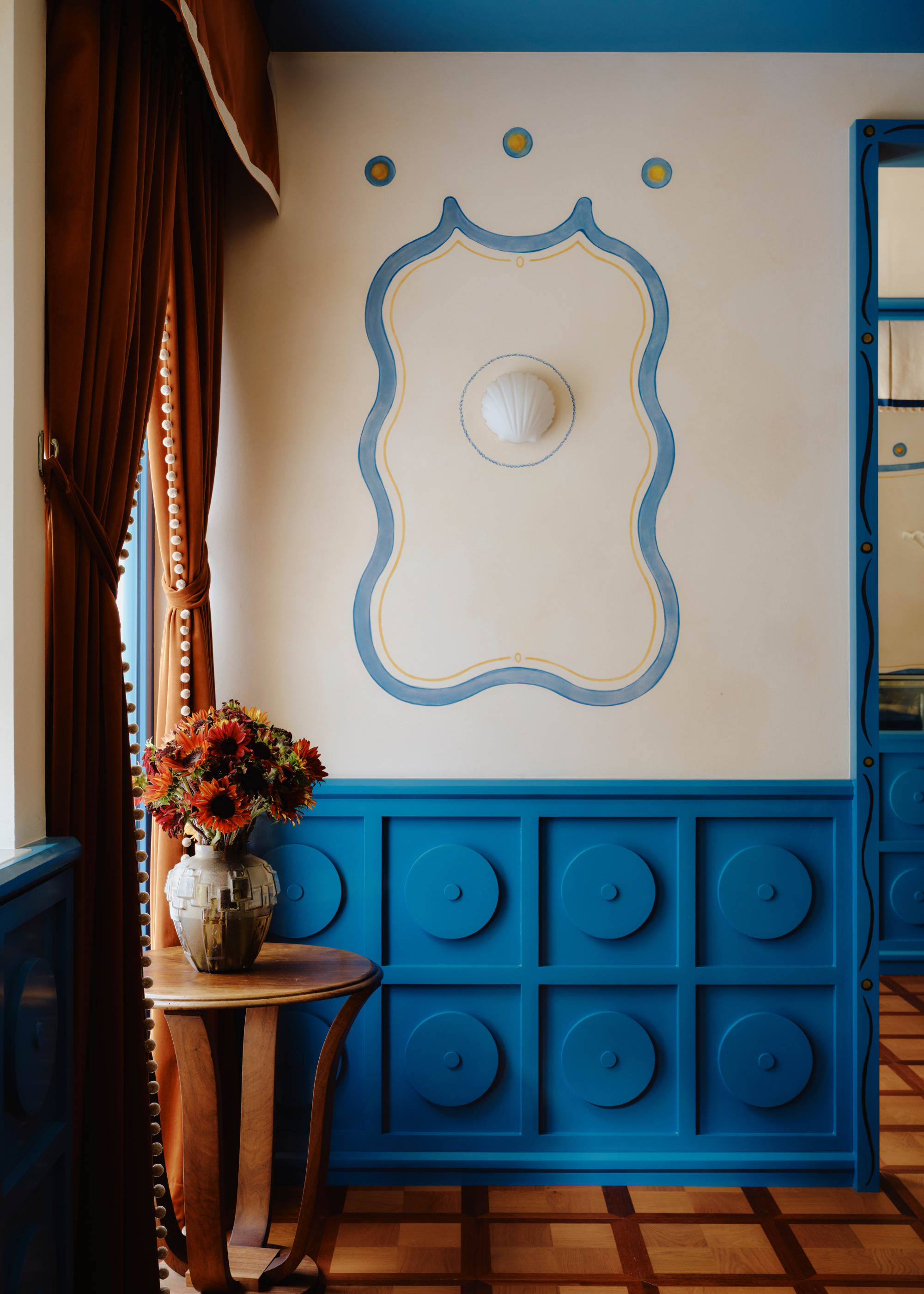 vibrant blue panelling and tiled floors with blue wall art in a cafe