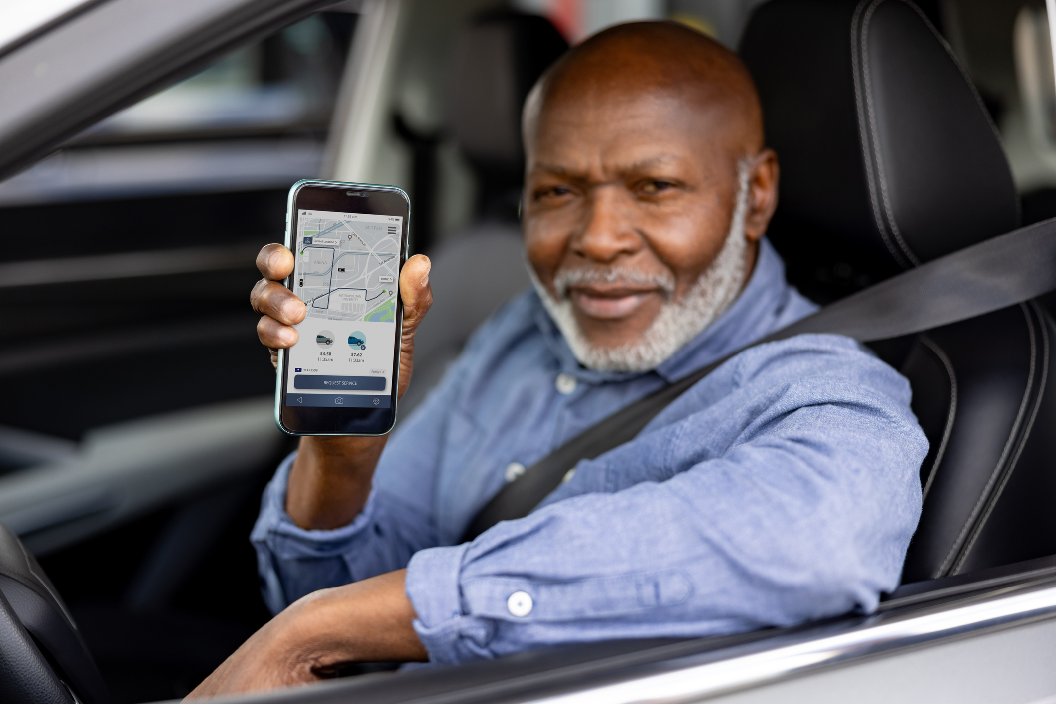 Uber driver showing the uber app on his phone.