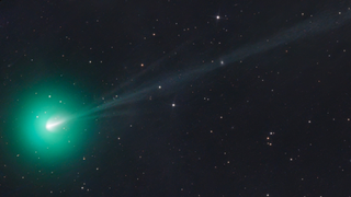 A green comet on a black backdrop with stars.