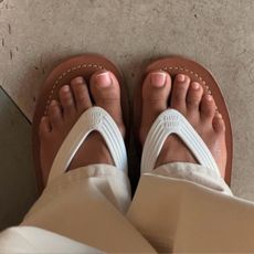 A photo of feet in Miu Miu flip flops